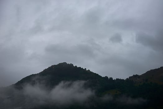 Mountain top surrounded by clouds and vegetation, mist, solitary, trees