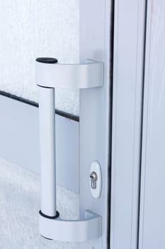 Lock and door handle on the plastic door close up