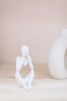 White gypsum decorative figure against beige background with copy space. Concept of template for website or commercial banner.