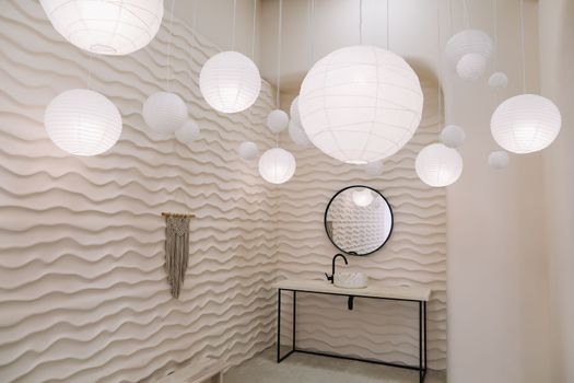 Modern interior with stylish round mirror by beige wall in a cozy room, copy space, elegant accessories in stylish home decor.