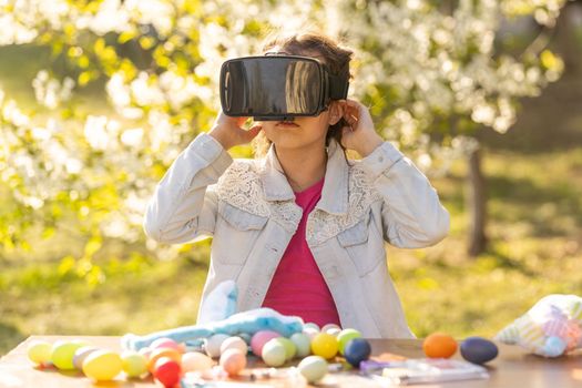 Teen gamer girl experiences fantasy world wearing virtual reality glasses with headphones. teenage girl with easter egg in virtual glasses