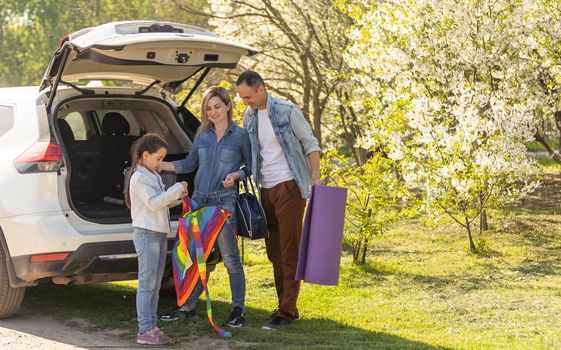 parents and child stopped for break by car. happy family travels by car. Car travel concept. healthy family.