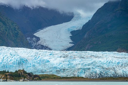 Milky light blue ocean by Amalia glacier with detail of the fissures and rocks in its path
