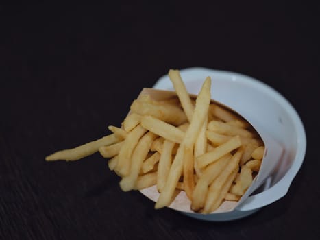 french fries or potato fry on  black wood . copy for space
