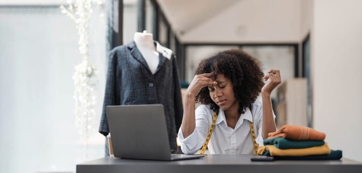 a Asian woman, a stylish fashion designer, thinking of problem to working, tried to new project, while a young businesswoman tries to recover after a long day's work in a clothing store