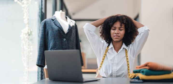 a Asian woman, a stylish fashion designer, thinking of problem to working, tried to new project, while a young businesswoman tries to recover after a long day's work in a clothing store