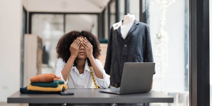 a Asian woman, a stylish fashion designer, thinking of problem to working, tried to new project, while a young businesswoman tries to recover after a long day's work in a clothing store