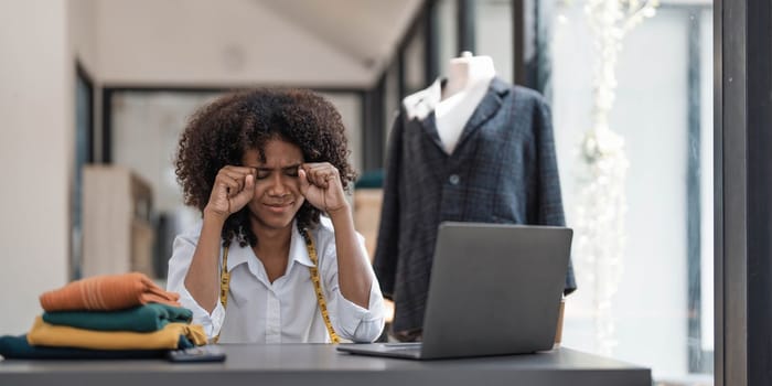 a Asian woman, a stylish fashion designer, thinking of problem to working, tried to new project, while a young businesswoman tries to recover after a long day's work in a clothing store