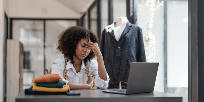 a Asian woman, a stylish fashion designer, thinking of problem to working, tried to new project, while a young businesswoman tries to recover after a long day's work in a clothing store