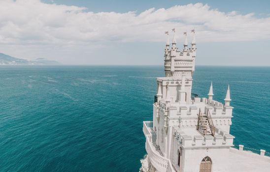 Aerial view of Swallow's Nest castle on the rock in Black Sea. It is a symbol and landmark of Crimea. Beautiful scenic panorama of the Crimea coast. Amazing Swallow's Nest at the precipice.