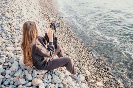 Woman travel sea. Happy tourist taking picture outdoors for memories. Woman traveler looks at the edge of the cliff on the sea bay of mountains, sharing travel adventure journey.