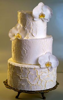 wedding bunk cake decorated with fresh flowers on a dark background