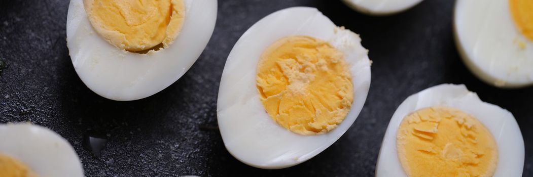 Sliced hard boiled eggs on dark background. Healthy food concept