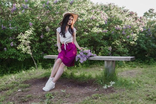 A fashionable girl with dark hair, a spring portrait in lilac tones in summer. Bright professional makeup