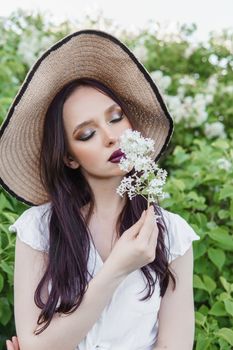 A fashionable girl with dark hair, a spring portrait in lilac tones in summer. Bright professional makeup