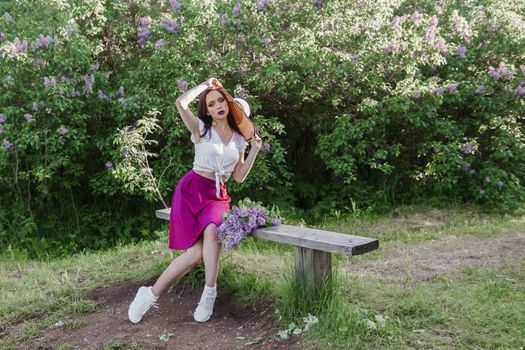 A fashionable girl with dark hair, a spring portrait in lilac tones in summer. Bright professional makeup