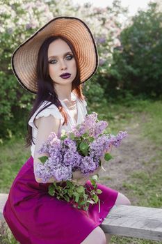 A fashionable girl with dark hair, a spring portrait in lilac tones in summer. Bright professional makeup