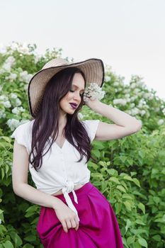 A fashionable girl with dark hair, a spring portrait in lilac tones in summer. Bright professional makeup