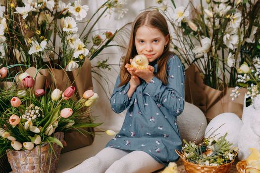Two girls in a beautiful Easter photo zone with flowers, eggs, chickens and Easter bunnies. Happy Easter holiday