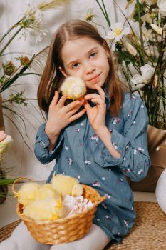 Two girls in a beautiful Easter photo zone with flowers, eggs, chickens and Easter bunnies. Happy Easter holiday