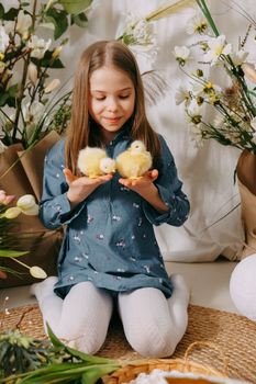 Two girls in a beautiful Easter photo zone with flowers, eggs, chickens and Easter bunnies. Happy Easter holiday