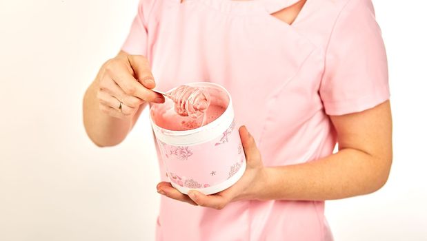 Woman holding sugar paste for hair removal. Depilation in a beauty salon.