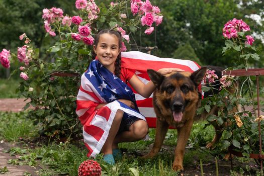 Happy little girl patriot running in the field with American flag. USA celebrate 4th of July. High quality photo