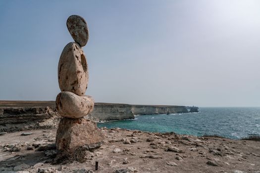 Sculpture symbol made of large pebbles against the blue sky.