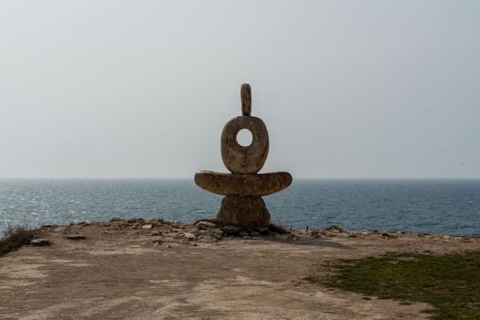 Sculpture symbol made of large pebbles against the blue sky.