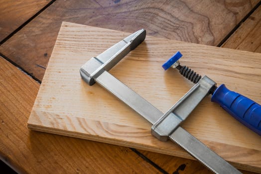 Restoration of an antique French wooden furniture using wood clamps to attach different parts of it