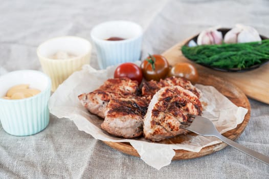 Fried pork in a fork with vegetables and sauce. Summer holiday concept
