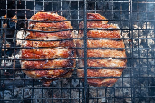 Grilling pork meat on the steel grid. Summer rest concept