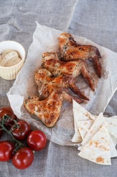 Ready spicy grilled chicken wings with greens and tomato. Summer rest concept