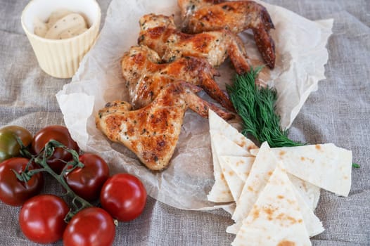 Ready spicy grilled chicken wings with greens and tomato. Summer rest concept