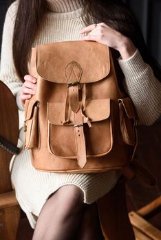 photo of a light brown leather backpack with antique and retro look. indoors photo.