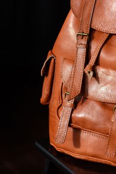 photo of a orange leather backpack with antique and retro look. indoors photo.