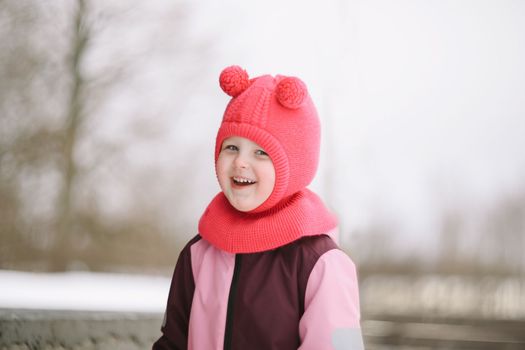 Happy adorable Funny little girl outdoors on a winter day.