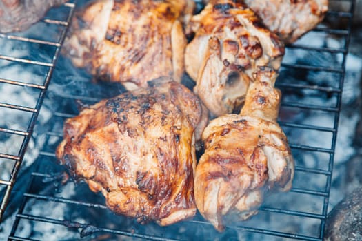 Chicken thighs Barbecue on The Hot Grill Close-up. Fire flames in the background