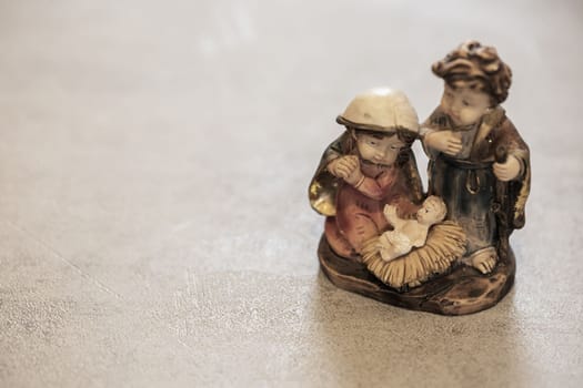 Close up of holy baby statue in nativity scene with on the table with copy space or text. Christmas religious traditions