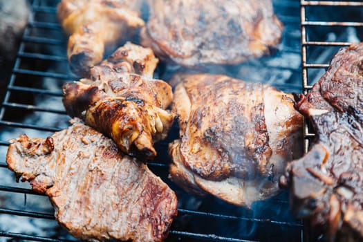 Chicken thighs Barbecue on The Hot Grill Close-up. Fire flames in the background