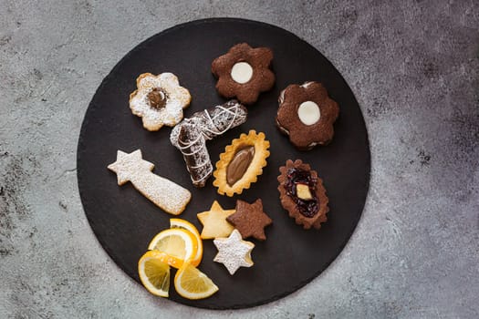 Tasty homemade Christmas cookies on black plate, closeup view