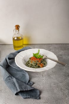 Healthy clean eating food: spirulina spaghetti with red caviar on concrete background with copy space, top view. Asian food creative concept