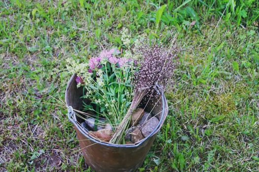 Wildflowers on a bucket on summer grass background