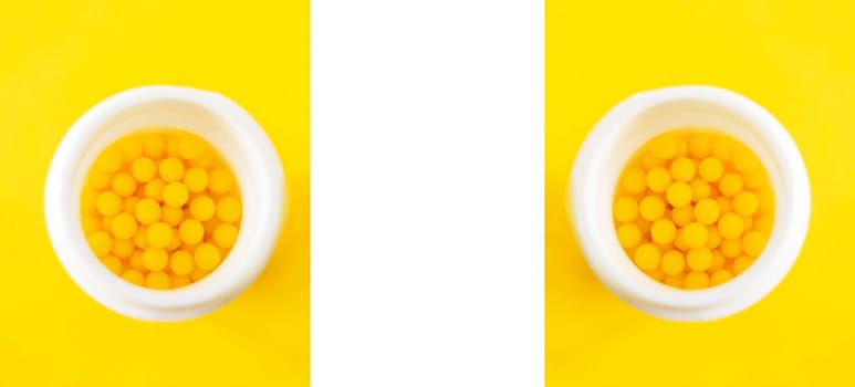 Pills of vitamin C in the opened white plastic container on bright yellow background. Symmetrical banner with copy space.