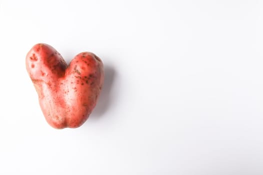 Heart shaped raw potato vegetable.Top view, copy space.