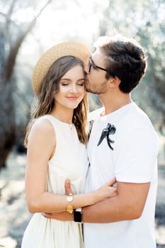 Man hugs and kisses woman on the forehead. High quality photo