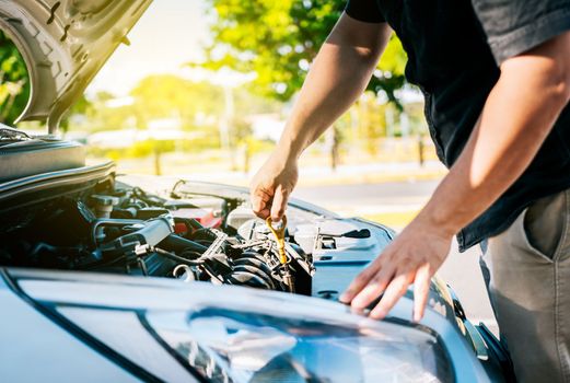 Driver hand inspecting car oil level. Man hand checking oil to car with copy space. People hand inspecting car oil level