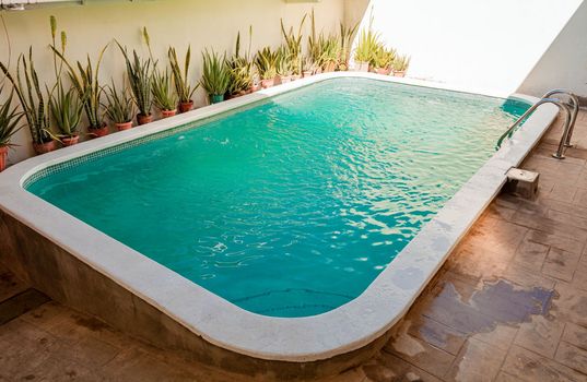 Beautiful home swimming pool with crystal clear waters. Crystal clear home swimming pool on a sunny day, Concept of home swimming pool designs