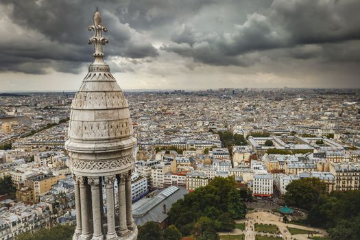 Paris skyline at dramatic storm clouds with La Defense above Montmartre parisien roofs, Paris, France