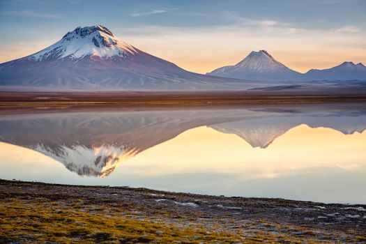 Salt lake Lejia reflection and idyllic volcanic landscape at Sunset, Atacama desert, Chile